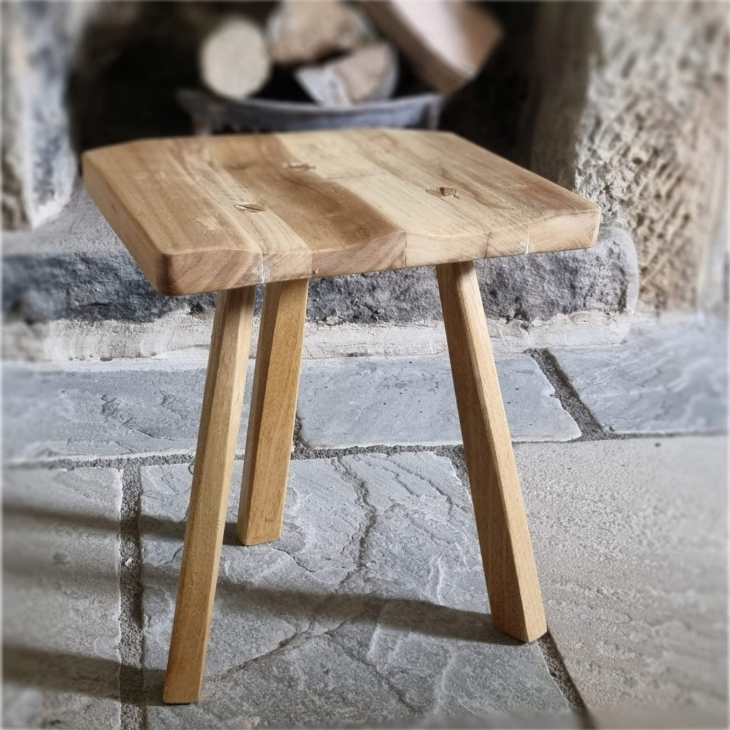 Wooden stool on a stone floor with a rustic background