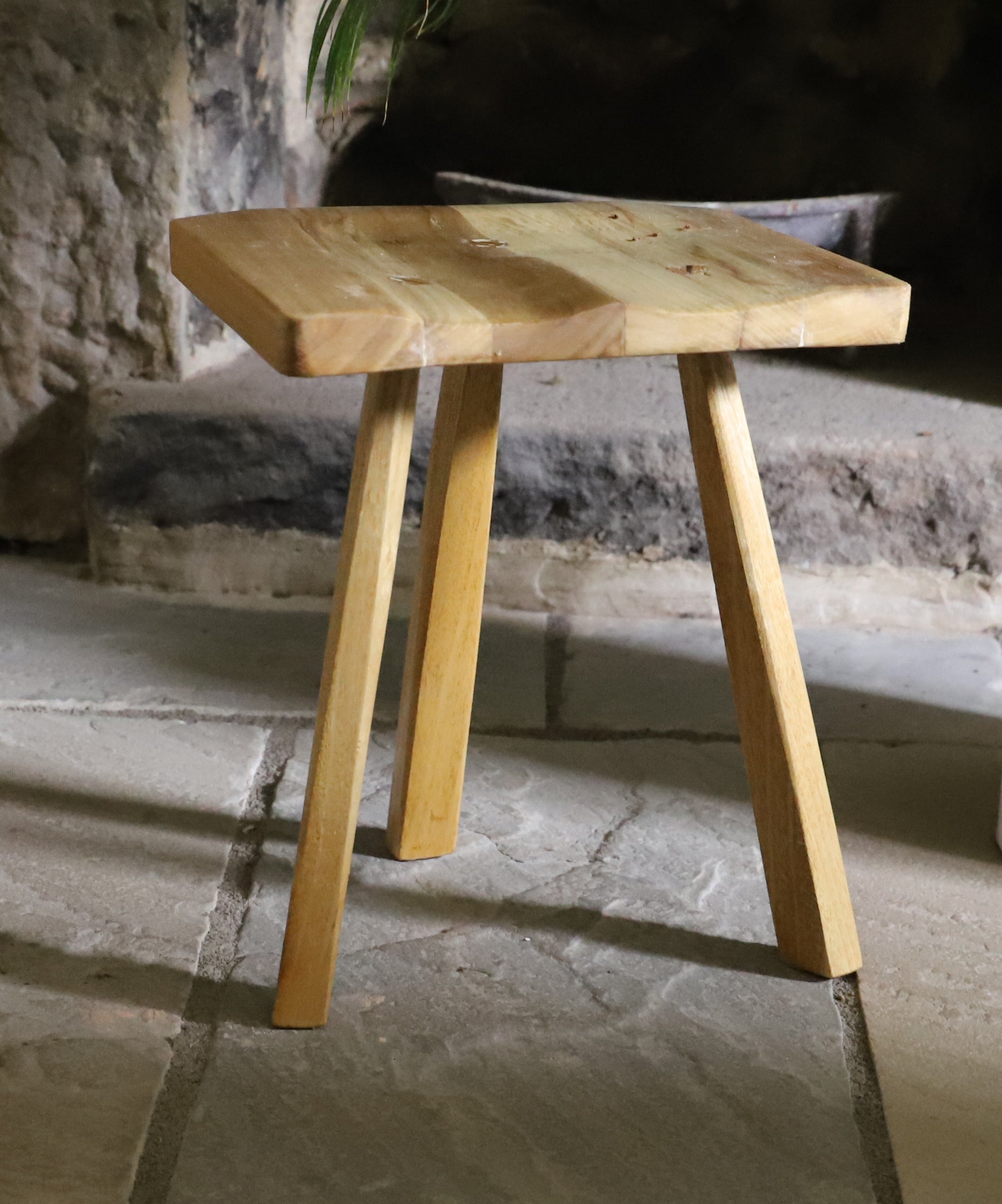 Wooden stool on a stone floor with a rustic background